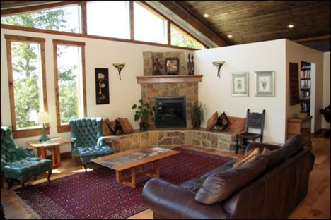 Foto de salón abierto bohemio grande con paredes blancas, suelo de madera clara, chimenea de esquina y marco de chimenea de piedra