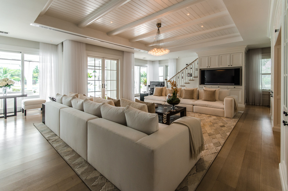Idee per un soggiorno stile marino aperto con pareti bianche, pavimento in legno massello medio e parete attrezzata
