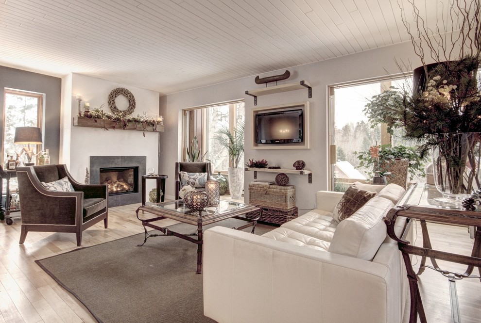 Inspiration for a classic open plan living room in Montreal with white walls, light hardwood flooring, a standard fireplace, a plastered fireplace surround, a built-in media unit and feature lighting.