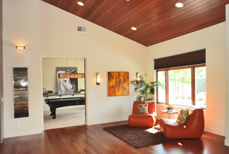 Foto de salón para visitas abierto actual pequeño sin chimenea y televisor con paredes beige, suelo de madera en tonos medios y suelo marrón