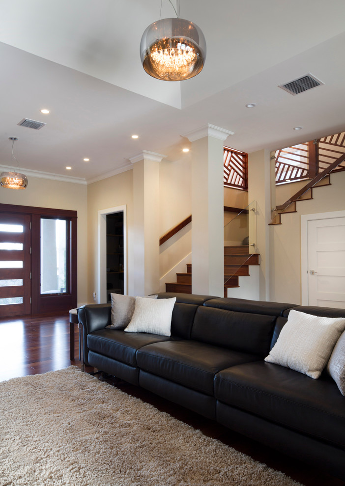 Cette image montre un grand salon design ouvert avec un mur beige et un sol en bois brun.