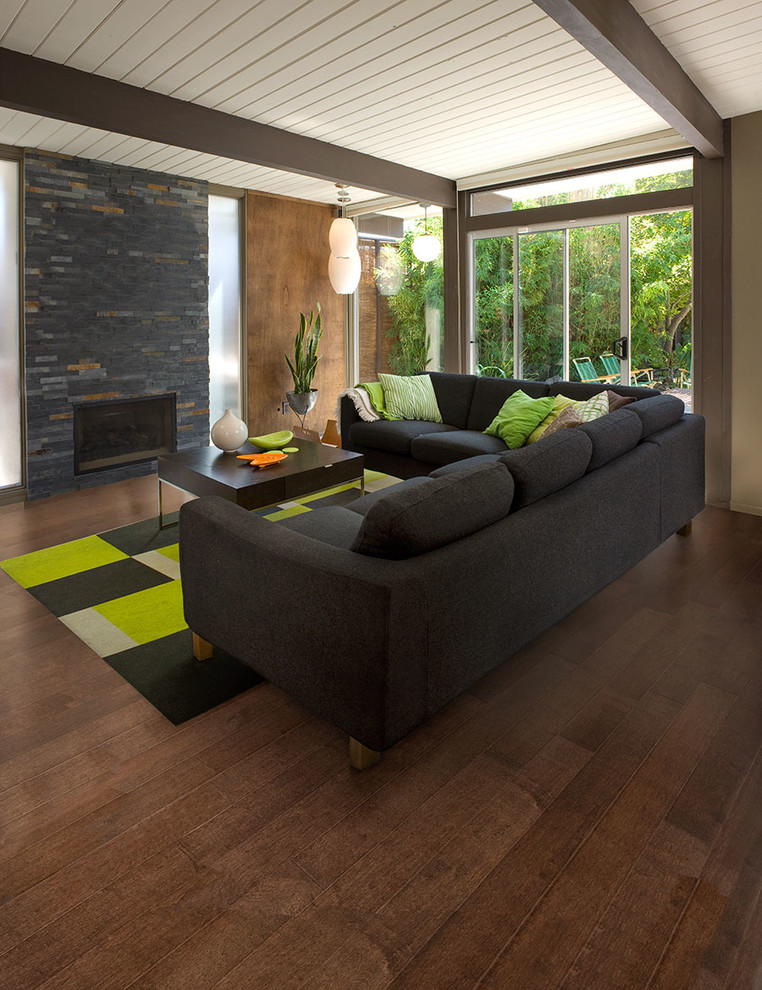 Cette image montre un salon minimaliste de taille moyenne et ouvert avec un mur multicolore, un sol en bois brun, un manteau de cheminée en brique, aucun téléviseur et une cheminée ribbon.