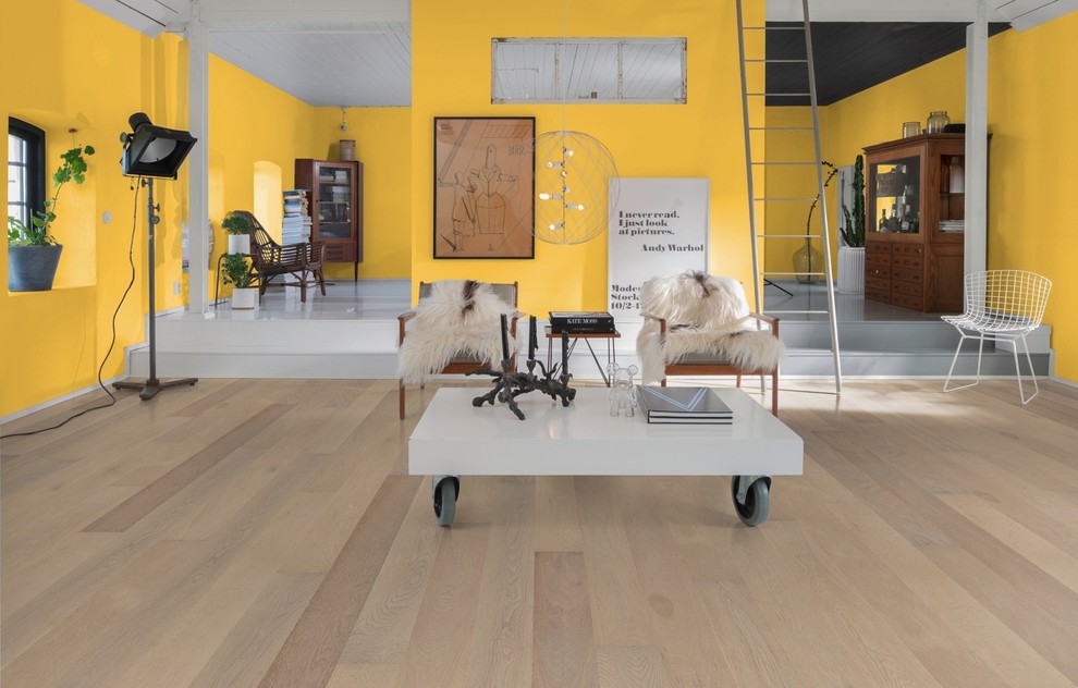 Modelo de salón abierto moderno con paredes amarillas y suelo de madera clara