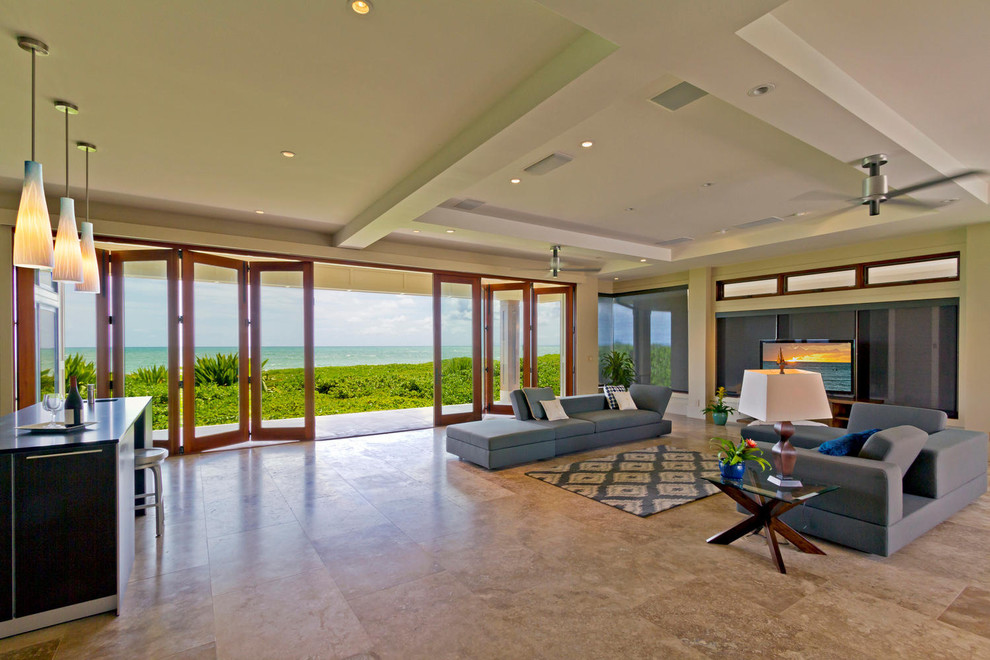 Immagine di un grande soggiorno minimal aperto con pareti beige, pavimento in travertino, TV autoportante e pavimento beige