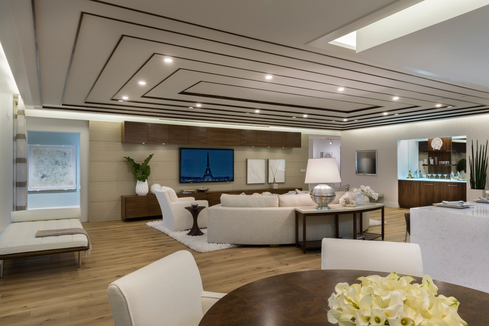 Пример оригинального дизайна: большая открытая гостиная комната в современном стиле с белыми стенами, светлым паркетным полом и телевизором на стене