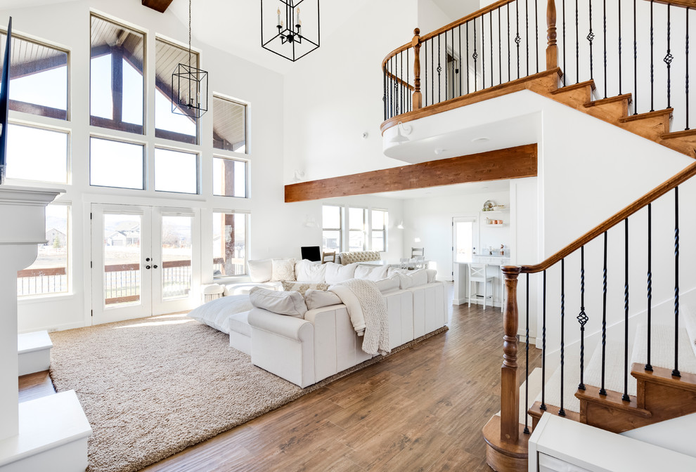Example of a large transitional formal and open concept porcelain tile and brown floor living room design in Salt Lake City with white walls, a standard fireplace, a wood fireplace surround and a wall-mounted tv