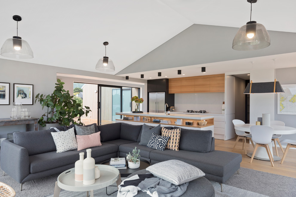 Großes, Repräsentatives, Offenes Modernes Wohnzimmer mit grauer Wandfarbe, Teppichboden, Hängekamin, Kaminumrandung aus Holz, freistehendem TV und grauem Boden in Wellington