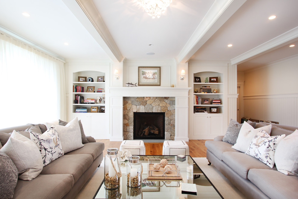 Photo of a medium sized classic formal open plan living room in Boston with white walls, medium hardwood flooring, a standard fireplace, a stone fireplace surround, no tv and brown floors.