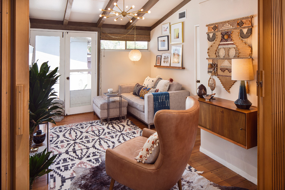 Modelo de salón para visitas cerrado retro con paredes beige, suelo de madera en tonos medios y suelo marrón