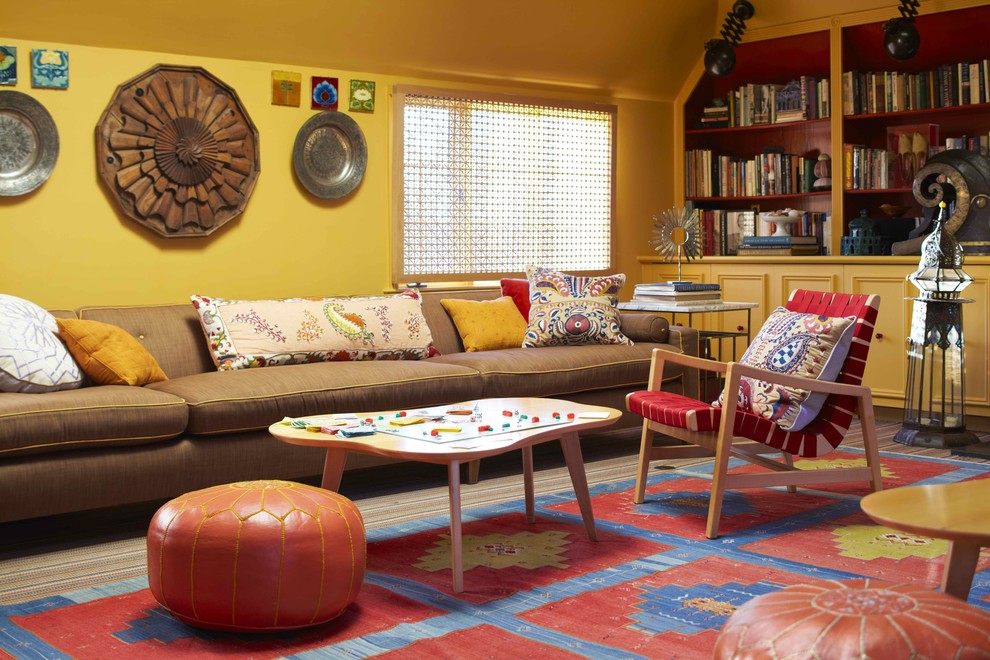 На фото: гостиная комната в современном стиле с с книжными шкафами и полками, желтыми стенами и ковром на полу