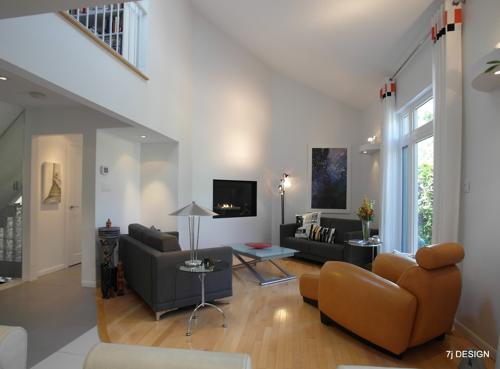 Foto de salón tipo loft moderno de tamaño medio con paredes blancas, suelo de madera en tonos medios y chimenea de esquina