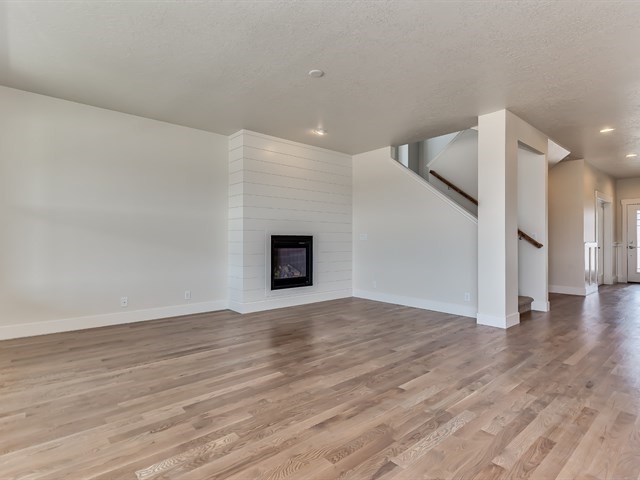 Large contemporary formal open plan living room in Boise with beige walls, light hardwood flooring, a standard fireplace, a tiled fireplace surround and no tv.