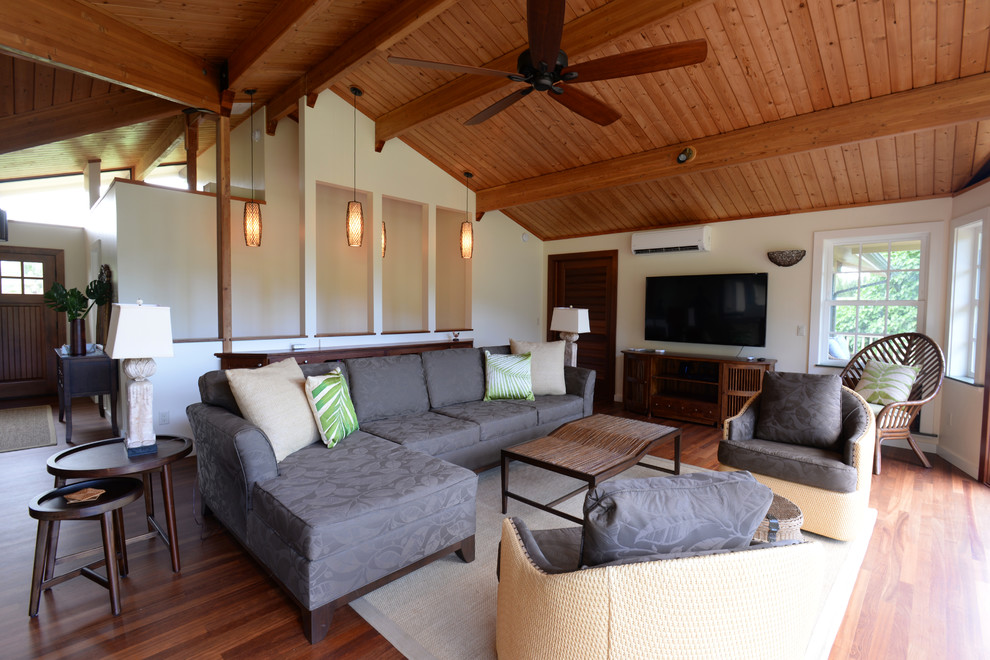 Diseño de salón abierto exótico grande sin chimenea con paredes blancas, suelo de madera en tonos medios, televisor colgado en la pared y suelo marrón
