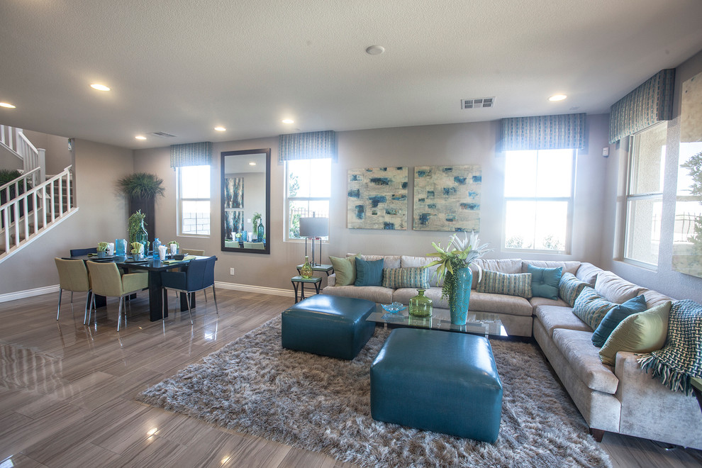 Large bohemian open plan living room in Las Vegas with grey walls and medium hardwood flooring.