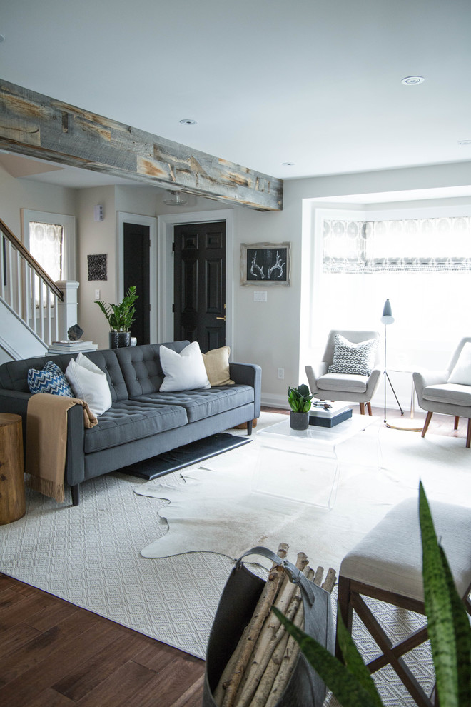 Kleines, Offenes Klassisches Wohnzimmer mit weißer Wandfarbe, braunem Holzboden, Kamin, gefliester Kaminumrandung, TV-Wand und braunem Boden in Toronto