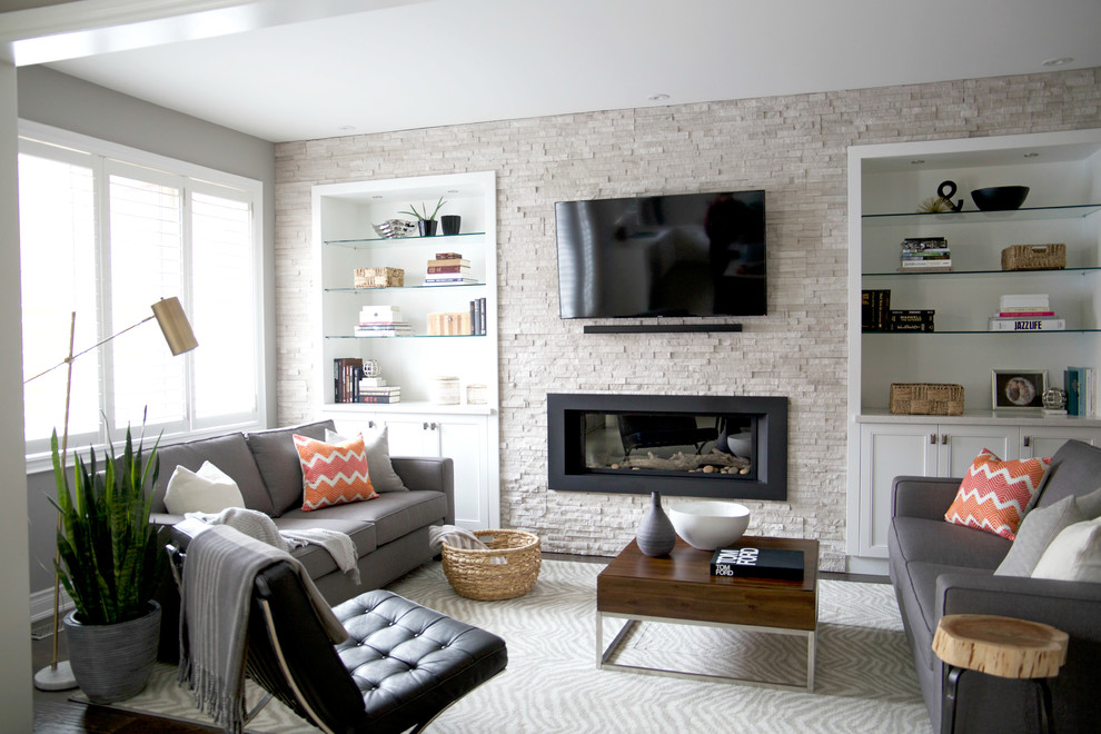 Aménagement d'un petit salon classique ouvert avec un mur blanc, un sol en bois brun, une cheminée standard, un manteau de cheminée en pierre, un téléviseur encastré et un sol marron.