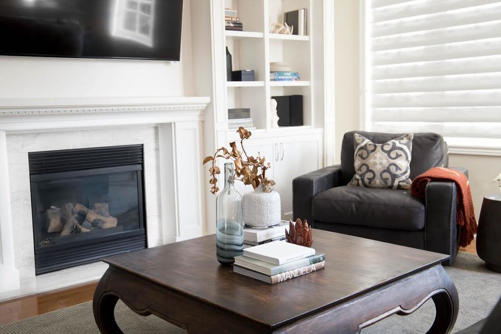 Kleines Klassisches Wohnzimmer mit beiger Wandfarbe, braunem Holzboden, Kamin, Kaminumrandung aus Stein, TV-Wand und braunem Boden in Toronto