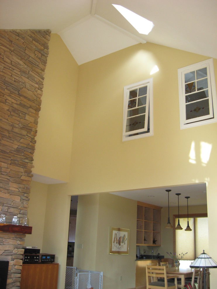 Idéer för ett mellanstort amerikanskt separat vardagsrum, med ett finrum, gula väggar, mellanmörkt trägolv, en standard öppen spis, en spiselkrans i sten och brunt golv