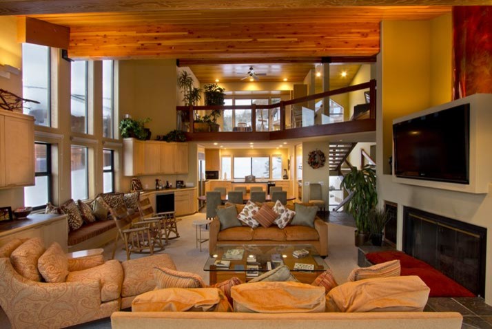 Aménagement d'un grand salon classique fermé avec un mur beige, moquette, une cheminée standard, un manteau de cheminée en bois et un téléviseur fixé au mur.