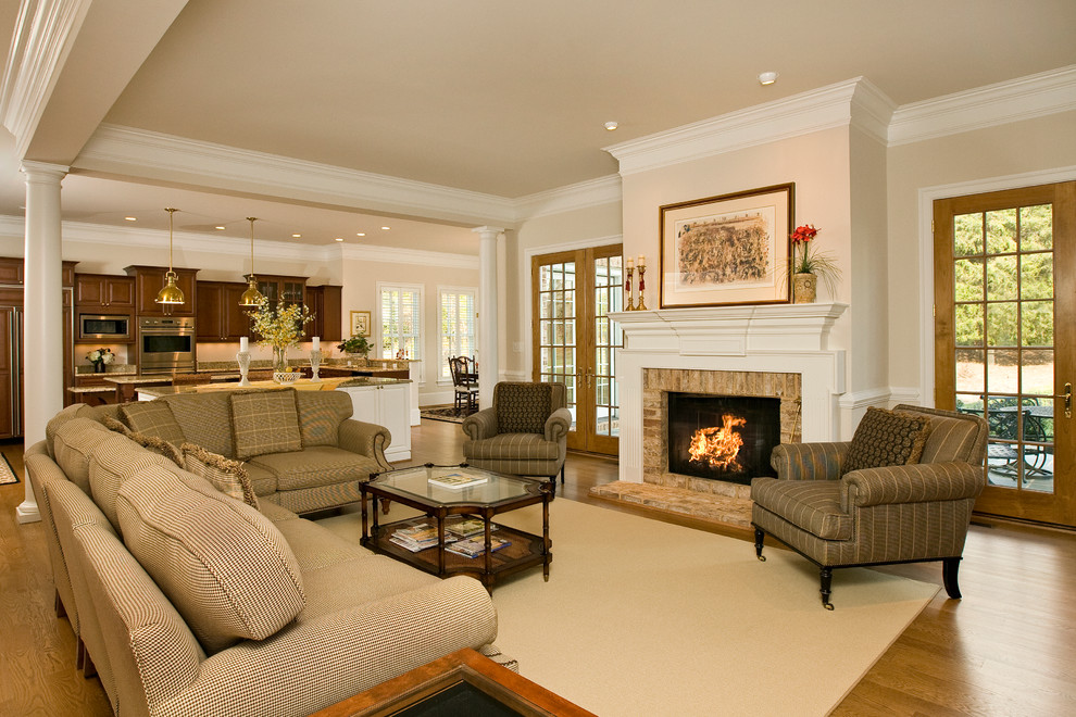 Inspiration for a timeless open concept medium tone wood floor living room remodel in Richmond with beige walls, a standard fireplace and a brick fireplace