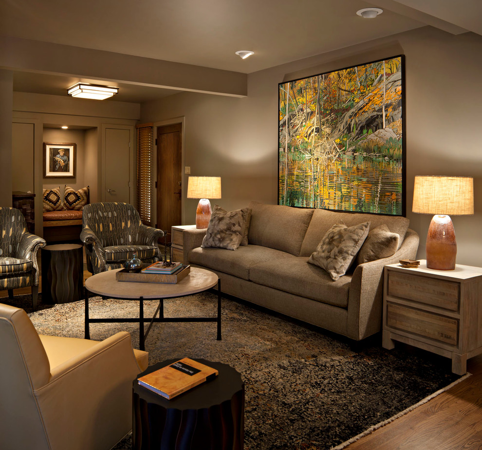 Mittelgroßes, Fernseherloses, Offenes Klassisches Wohnzimmer mit grüner Wandfarbe, braunem Holzboden, Kamin und Kaminumrandung aus Stein in Calgary