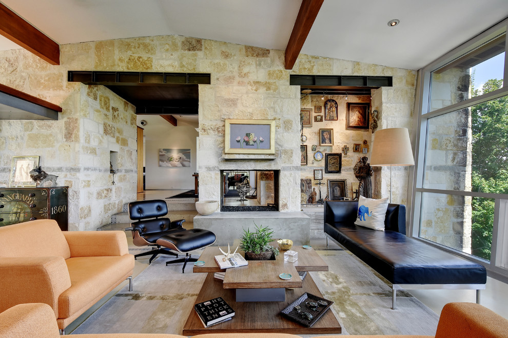 Cette image montre un salon design ouvert avec une salle de réception, une cheminée double-face, aucun téléviseur et un mur en pierre.