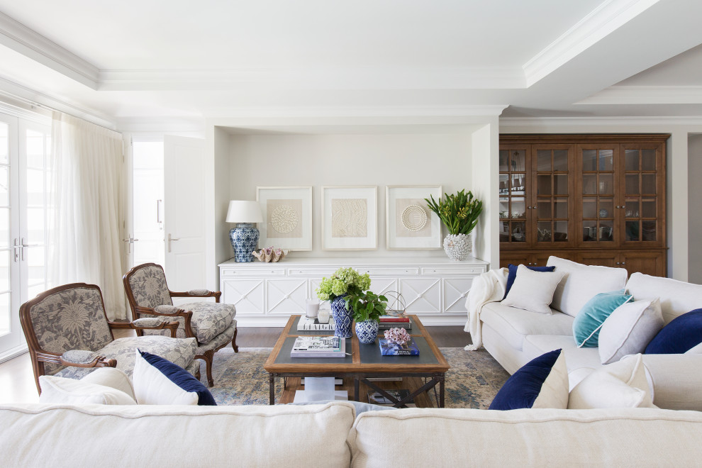 Immagine di un soggiorno classico aperto con pareti beige, parquet scuro, pavimento marrone e soffitto ribassato