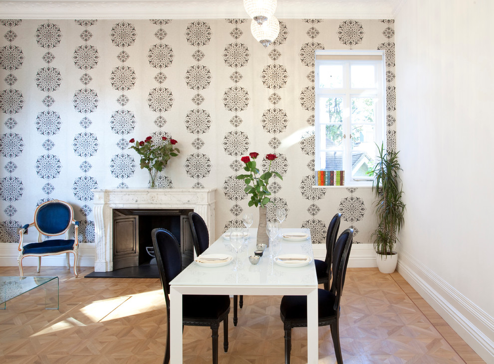 Inspiration pour une salle à manger nordique avec un mur multicolore, parquet clair et une cheminée standard.
