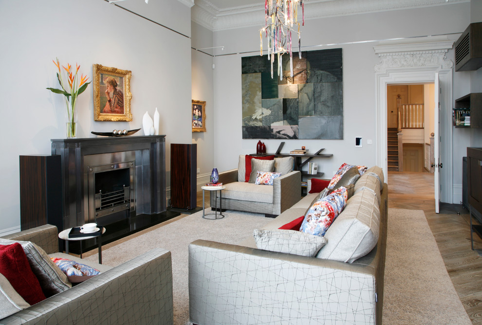 Стильный дизайн: парадная гостиная комната в современном стиле с серыми стенами, стандартным камином, фасадом камина из металла и паркетным полом среднего тона - последний тренд