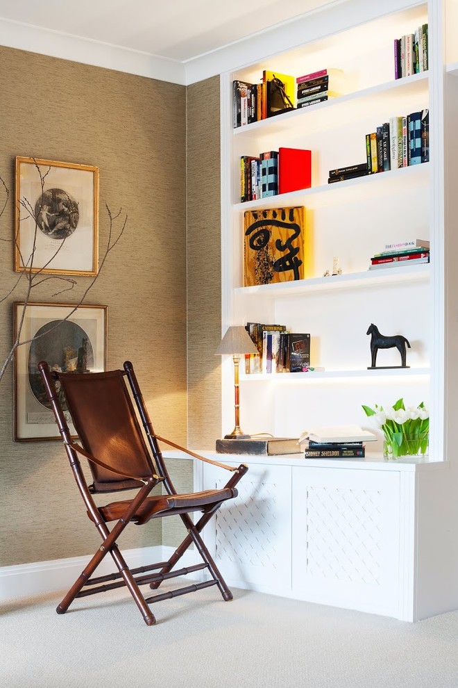 На фото: изолированная гостиная комната среднего размера в скандинавском стиле с ковровым покрытием, с книжными шкафами и полками, бежевыми стенами и мультимедийным центром с