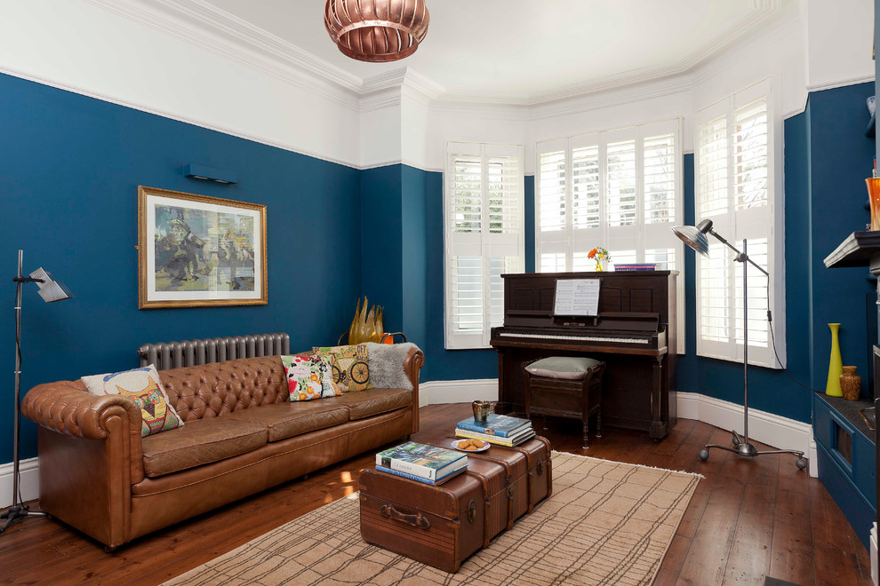 Medium sized bohemian formal enclosed living room in Kent with blue walls, brown floors and dark hardwood flooring.
