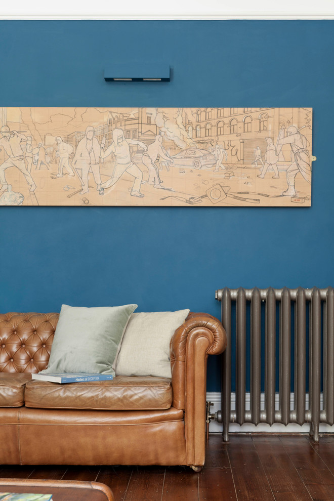 Esempio di un soggiorno eclettico di medie dimensioni con pareti blu, pavimento in laminato, camino classico e pavimento marrone