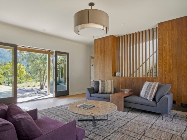 Idée de décoration pour un salon design ouvert avec un mur blanc, un sol en bois brun, une cheminée ribbon et un manteau de cheminée en métal.