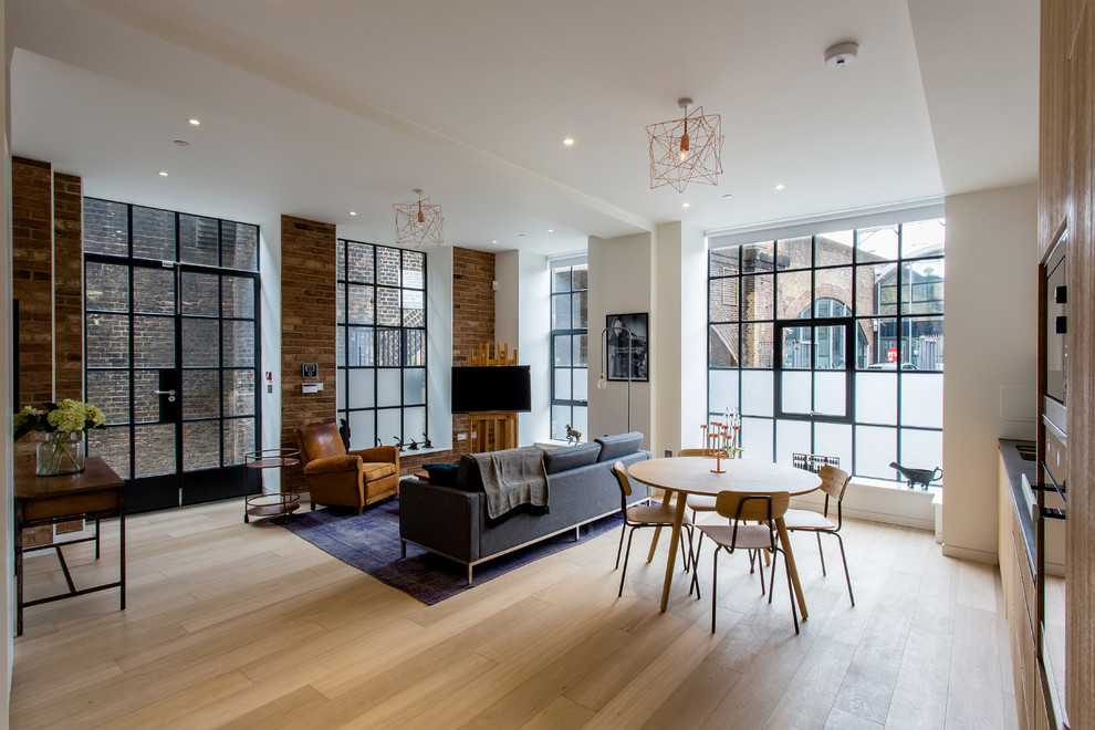 Design ideas for an urban open plan living room in London with white walls and light hardwood flooring.