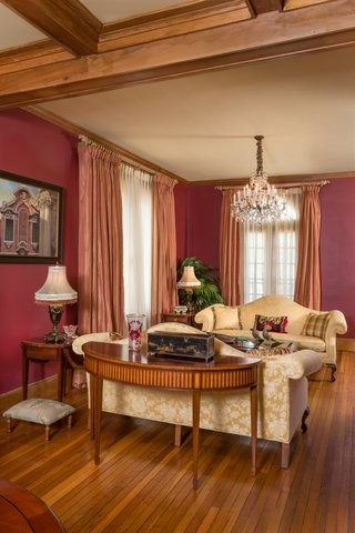 Mittelgroßes, Repräsentatives Klassisches Wohnzimmer mit roter Wandfarbe und hellem Holzboden in New Orleans