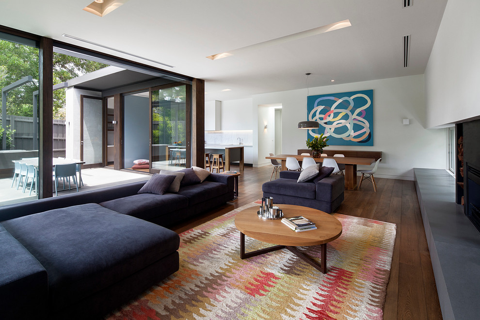 Großes, Offenes Modernes Wohnzimmer mit weißer Wandfarbe, dunklem Holzboden und Kamin in Melbourne