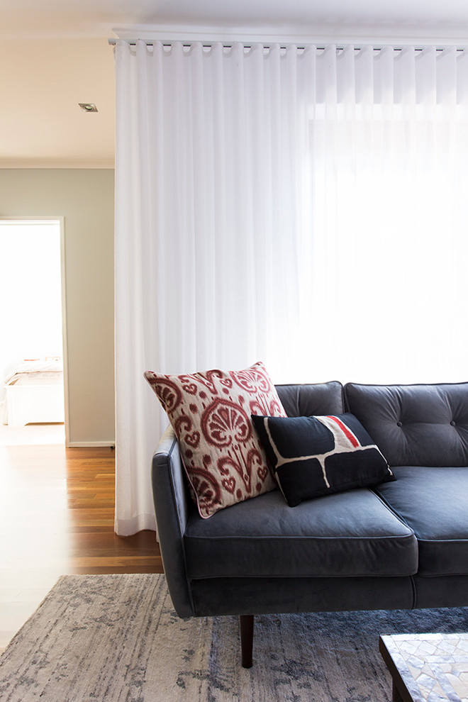 Idee per un piccolo soggiorno design aperto con pareti blu, pavimento in legno massello medio, nessun camino e TV autoportante
