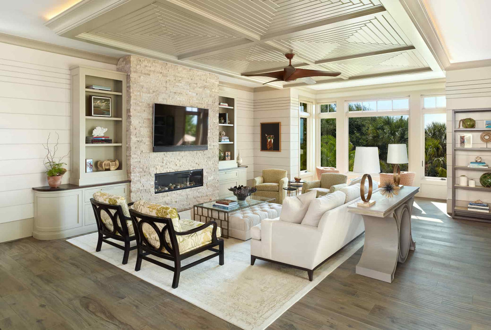 Maritimes Wohnzimmer mit weißer Wandfarbe, dunklem Holzboden, Gaskamin, Kaminumrandung aus Stein, TV-Wand und Holzdielenwänden in Charleston