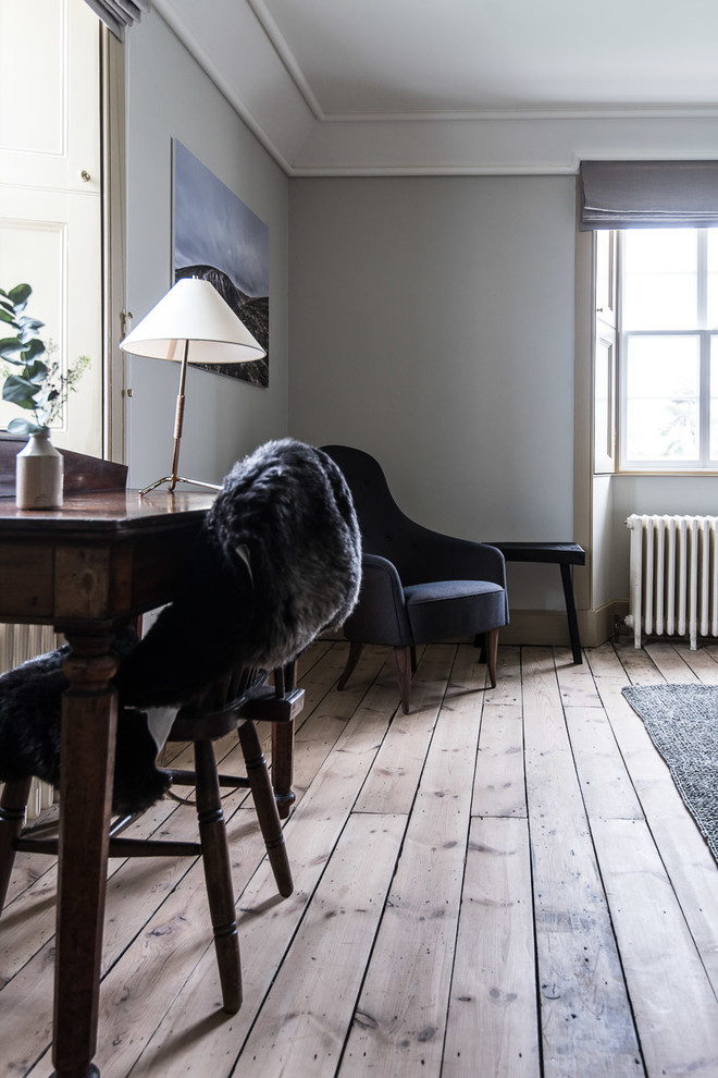 Immagine di un soggiorno minimal di medie dimensioni e chiuso con pareti grigie, pavimento in legno massello medio, camino classico e cornice del camino in legno