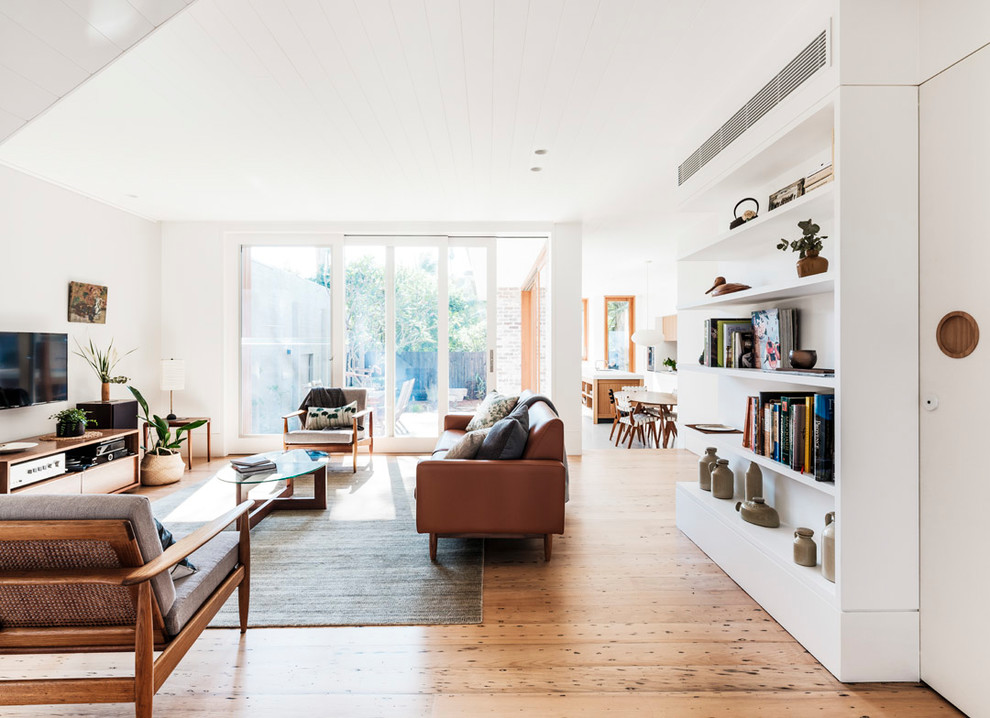 Mittelgroßes, Offenes Modernes Wohnzimmer ohne Kamin mit weißer Wandfarbe, hellem Holzboden, TV-Wand und beigem Boden in Sydney