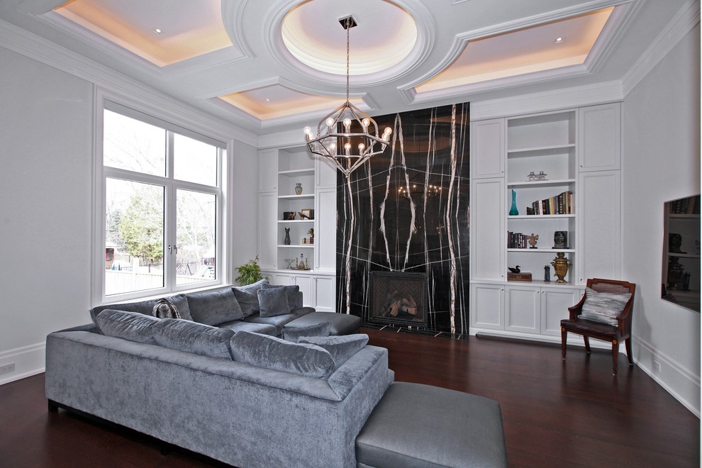 Großes, Repräsentatives, Offenes Klassisches Wohnzimmer mit grauer Wandfarbe, dunklem Holzboden, Kamin, Kaminumrandung aus Stein, TV-Wand und braunem Boden in Toronto