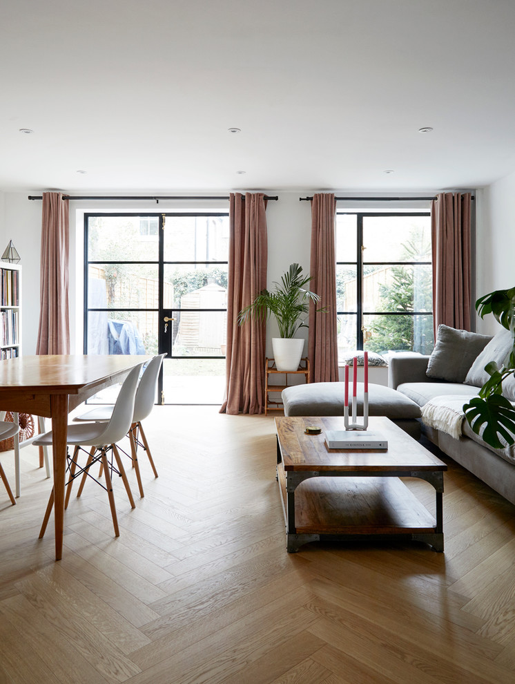 Cette image montre un salon nordique de taille moyenne et ouvert avec un mur blanc et parquet clair.