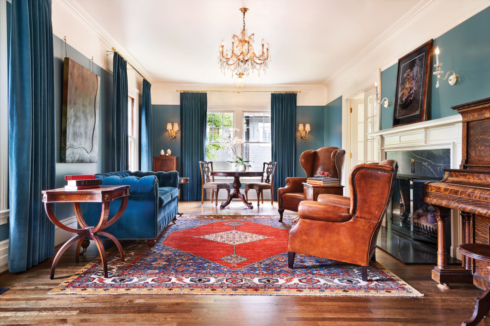 Aménagement d'un salon classique fermé avec une salle de réception, un mur bleu, parquet foncé, une cheminée standard, un manteau de cheminée en pierre et un sol marron.