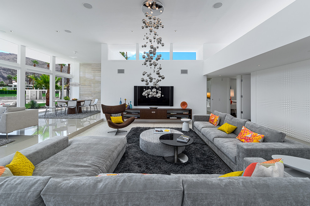 Immagine di un soggiorno minimalista aperto con pareti bianche, pavimento in travertino e TV a parete
