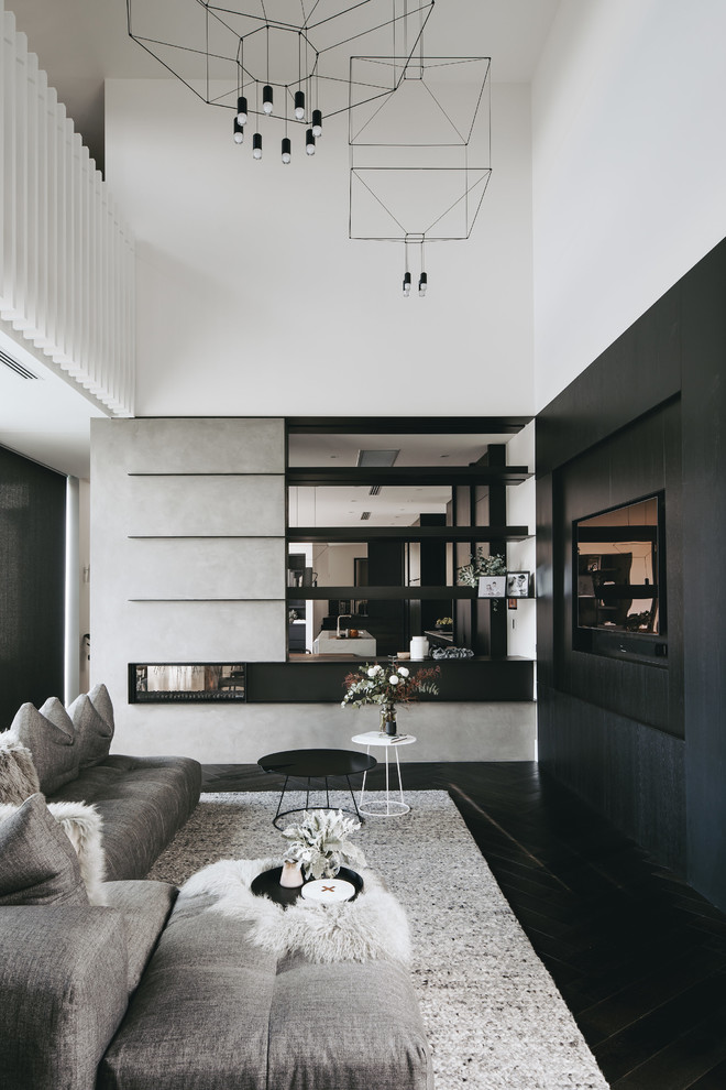 Источник вдохновения для домашнего уюта: гостиная комната в современном стиле с белыми стенами, темным паркетным полом, двусторонним камином, телевизором на стене и черным полом