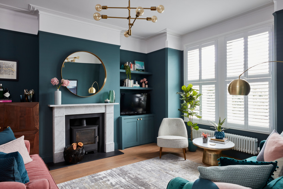 Inspiration for a medium sized classic enclosed living room in Kent with green walls, a tiled fireplace surround, a freestanding tv, brown floors, medium hardwood flooring and a wood burning stove.