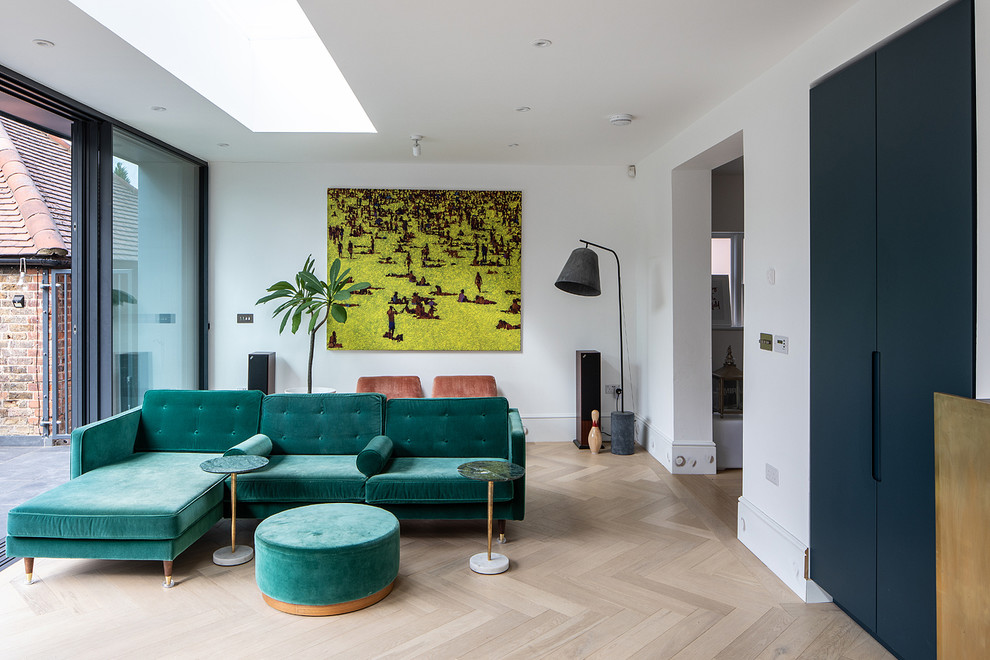 Immagine di un soggiorno design con pareti bianche, parquet chiaro e pavimento beige