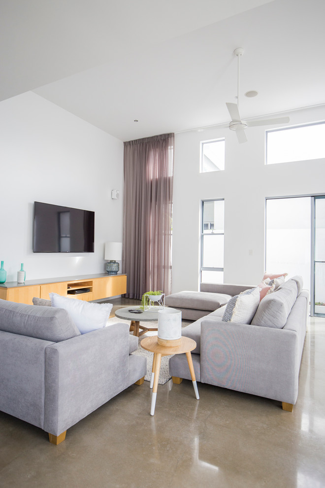 Immagine di un grande soggiorno design aperto con pavimento in cemento e TV a parete
