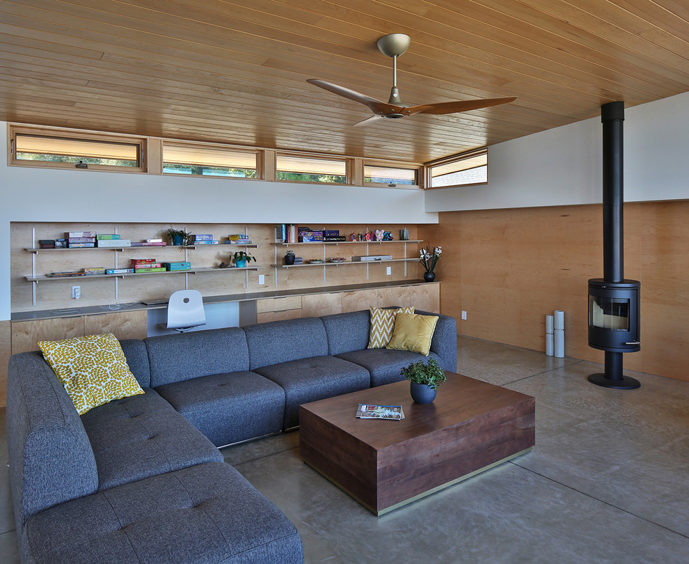 Medium sized modern open plan living room in Seattle with multi-coloured walls, concrete flooring, a wood burning stove, a concrete fireplace surround and grey floors.