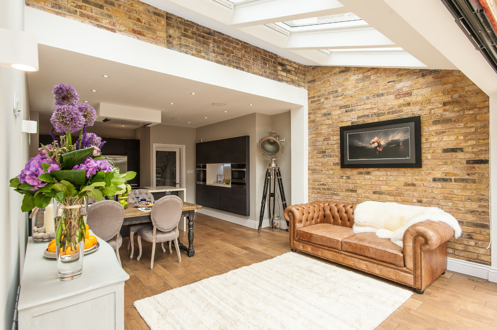 Offenes Eklektisches Wohnzimmer mit bunten Wänden und braunem Holzboden in London